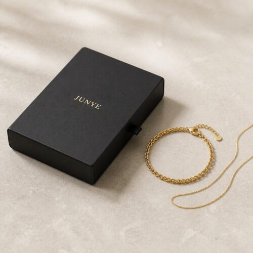 Black flat drawer jewelry packaging box styled with a gold chain and bracelet