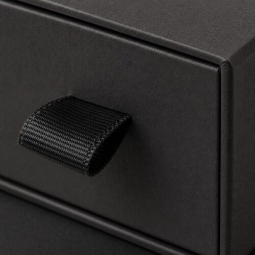 Black grosgrain fabric pull tab on the sliding tray of a custom rigid jewelry box, close up