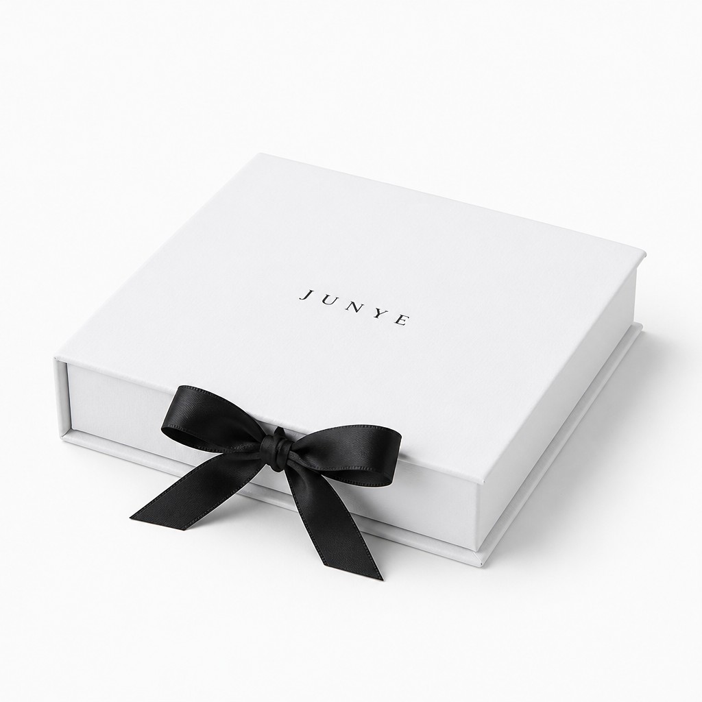 Closed white magnetic flip box with the black satin bow tied at the front edge