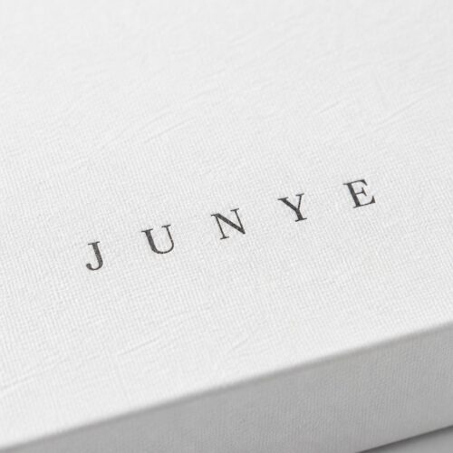 Macro of the JUNYE mark printed on matte white specialty paper