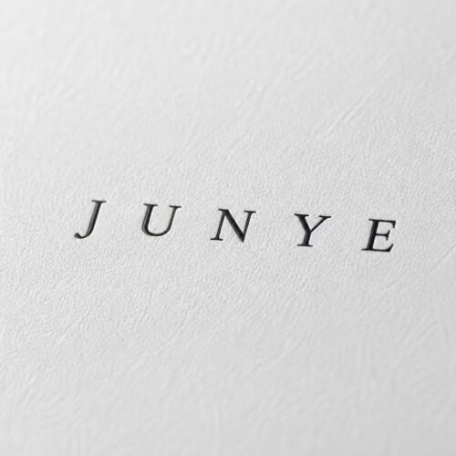 Macro of the matte white specialty paper and the printed JUNYE logo on a drawer jewelry box