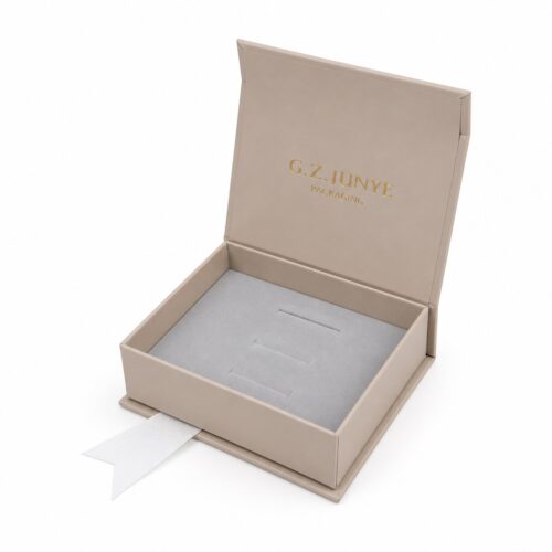Beige jewelry box with the lid open showing the light grey flocked insert with narrow slots cut for a row of rings