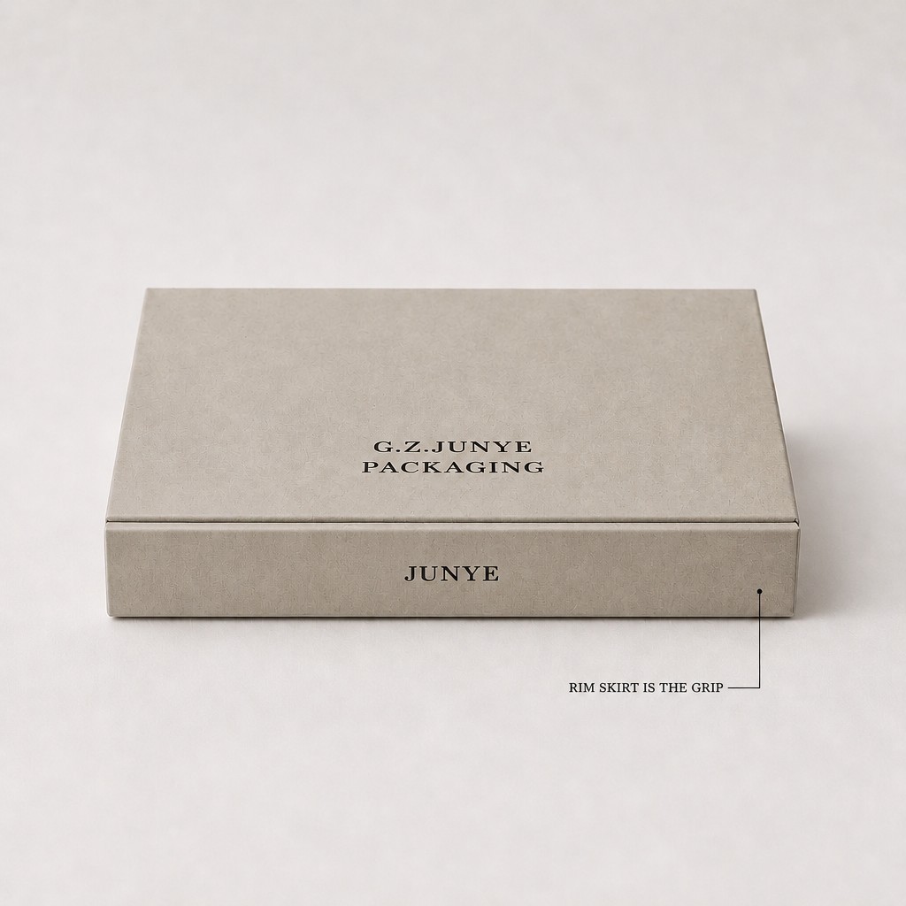Closed light grey-beige rim fold jewelry case, with the rim skirt at the tray end marked as the grip
