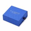 Blue square drawer jewelry box closed, with the navy ribbon pull on the front of the tray
