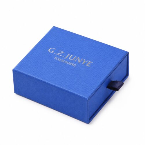 Blue square drawer jewelry box closed, with the navy ribbon pull on the front of the tray