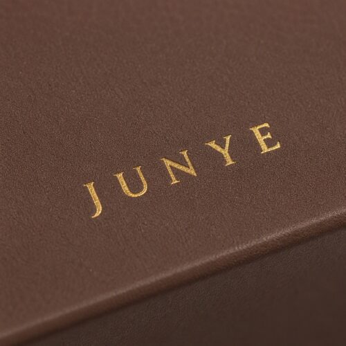 Macro of the gold foil JUNYE mark on brown specialty paper