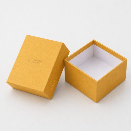 Open gold embossed rigid box with the lid off and the white lined tray