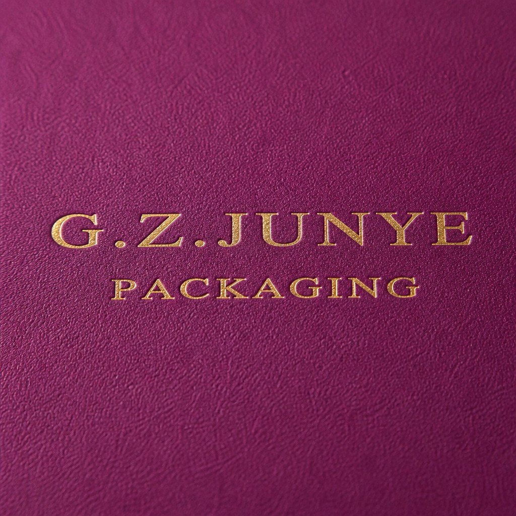 Gold G.Z.JUNYE PACKAGING stamp on the matte magenta specialty paper of a drawer jewelry box