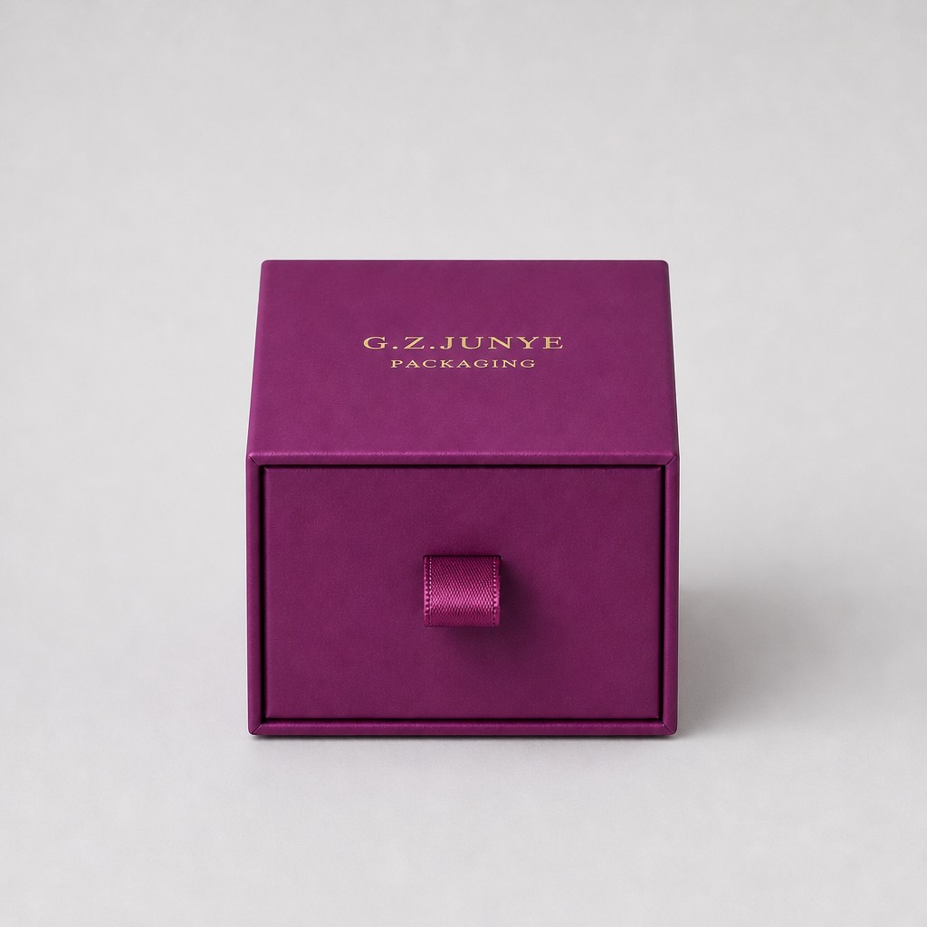 Magenta drawer jewelry box closed with the satin ribbon pull tab at the centre of the drawer face