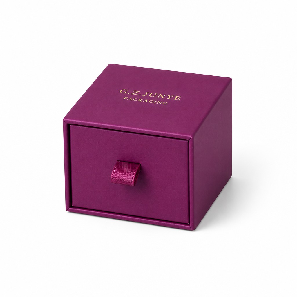 Magenta drawer jewelry box closed with the satin ribbon pull tab at the centre of the drawer face