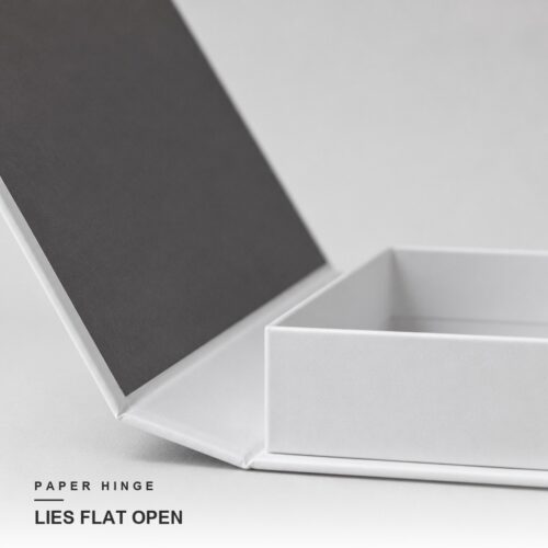 Cover swung flat on its paper hinge with the white tray open beside it
