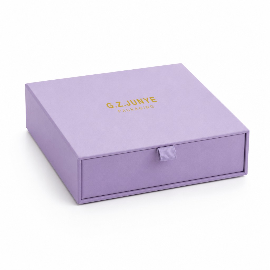 Closed purple drawer box from the back at a low angle, matte purple wrap and the gold foil block on the sleeve top