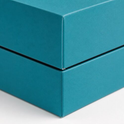Detail of the skirted lid edge and the wrapped corner on a teal rimmed lid and base box