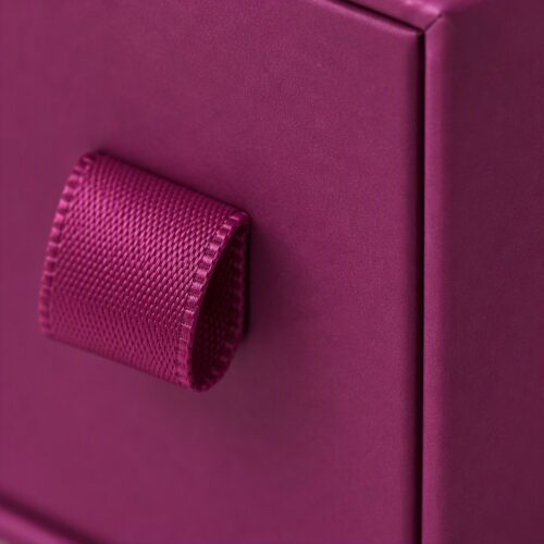Close up of the satin ribbon pull tab fixed at the centre of the drawer face