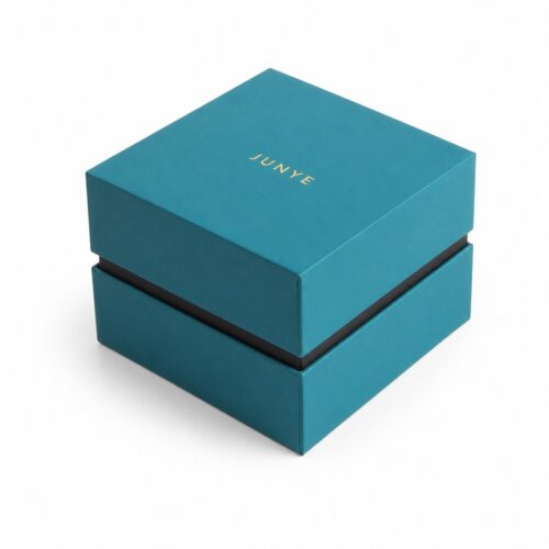 Teal rimmed lid and base jewelry packaging box closed, with the skirted lid sitting over the base tray